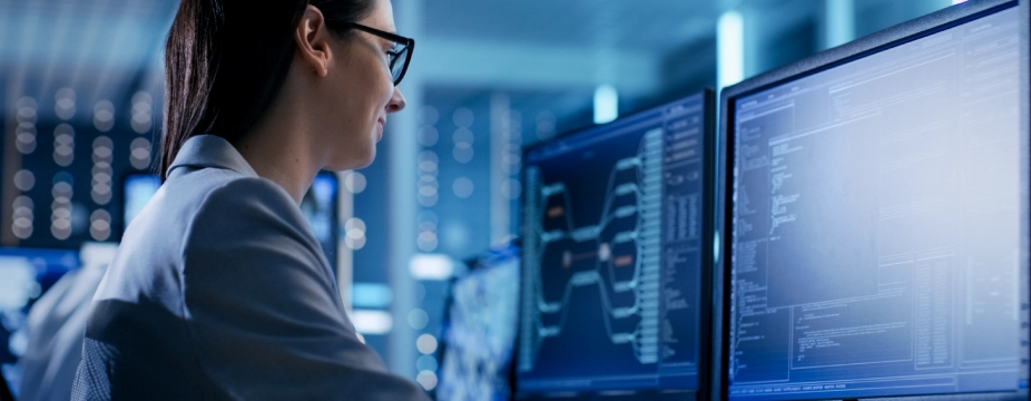 professional engineer analyzing data dashboards on dual monitors using Open iT license monitoring software as part of the Open iT product suite.